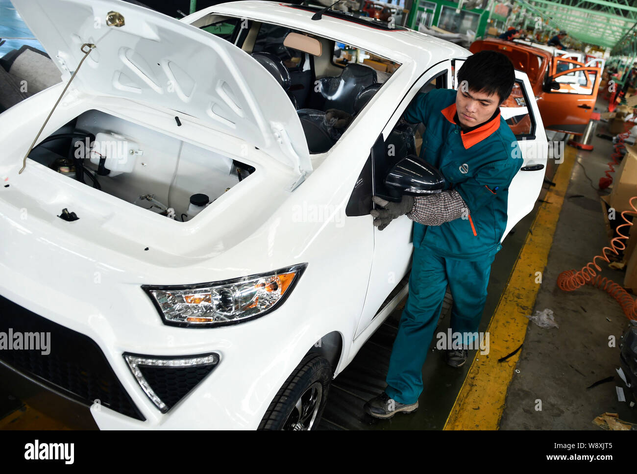 A Chinese worker assembles a car on the assembly line at an auto plant ...