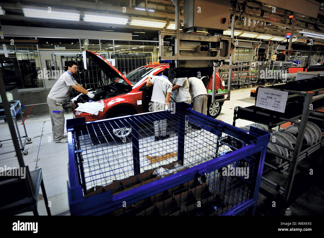 --FILE--Chinese workers assemble a car on the assembly line at the Foshan factory of FAW-Volkswagen Auto Co., Ltd. in Foshan city, south China's Guang Stock Photo