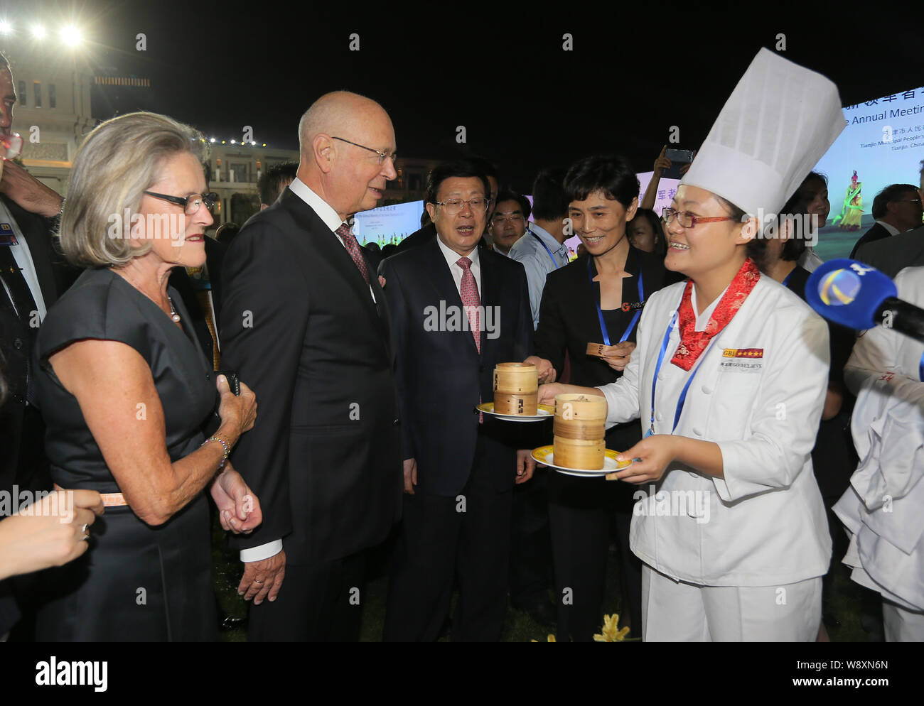 A cook serves food to Klaus Schwab, second left, Founder and Executive Chairman of the World Economic Forum, and his wife Hilde Schwab, left, at the c Stock Photo