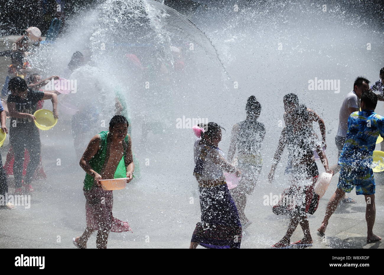 Chinese tourists and entertainers splash water during the water ...