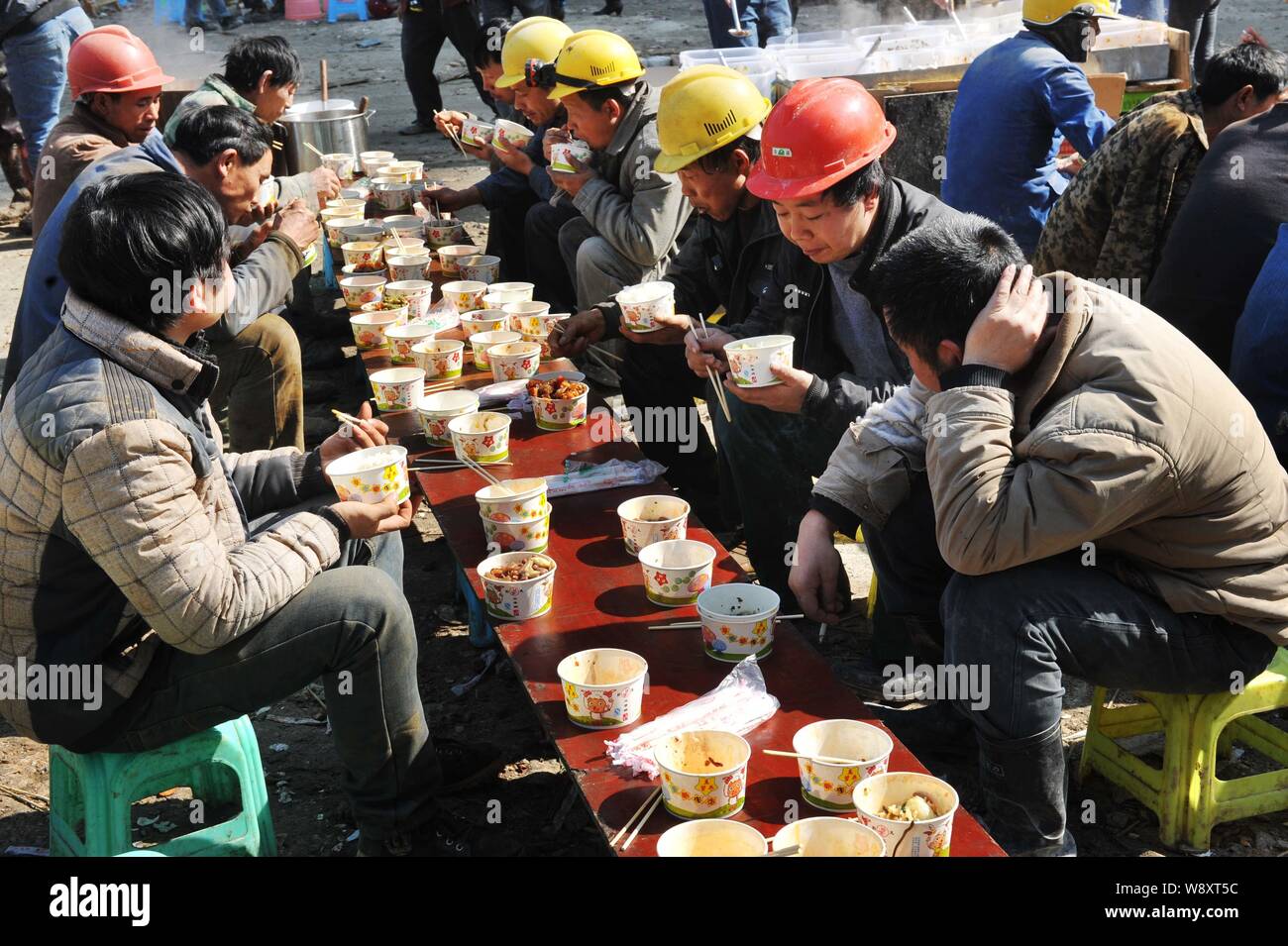 Chinese migrant workers eat lunch at the construction site of a