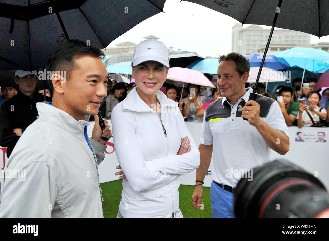 Australian actress Nicole Kidman, center, poses with Mission Hills Group vice chairman Zhu Dingyao, left, during the 2014 Mission Hills World Celebrit Stock Photo