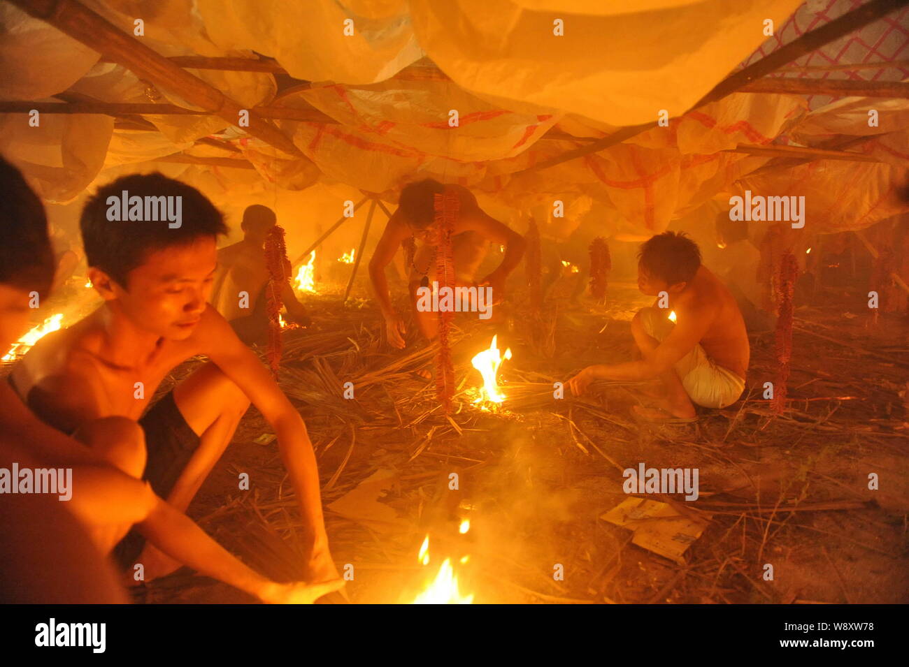 Villagers ignite firecrackers to release a 40-meter-diameter paper sky lantern at a local ritual ceremony to mark the Chinese Hungry Ghost Festival in Stock Photo