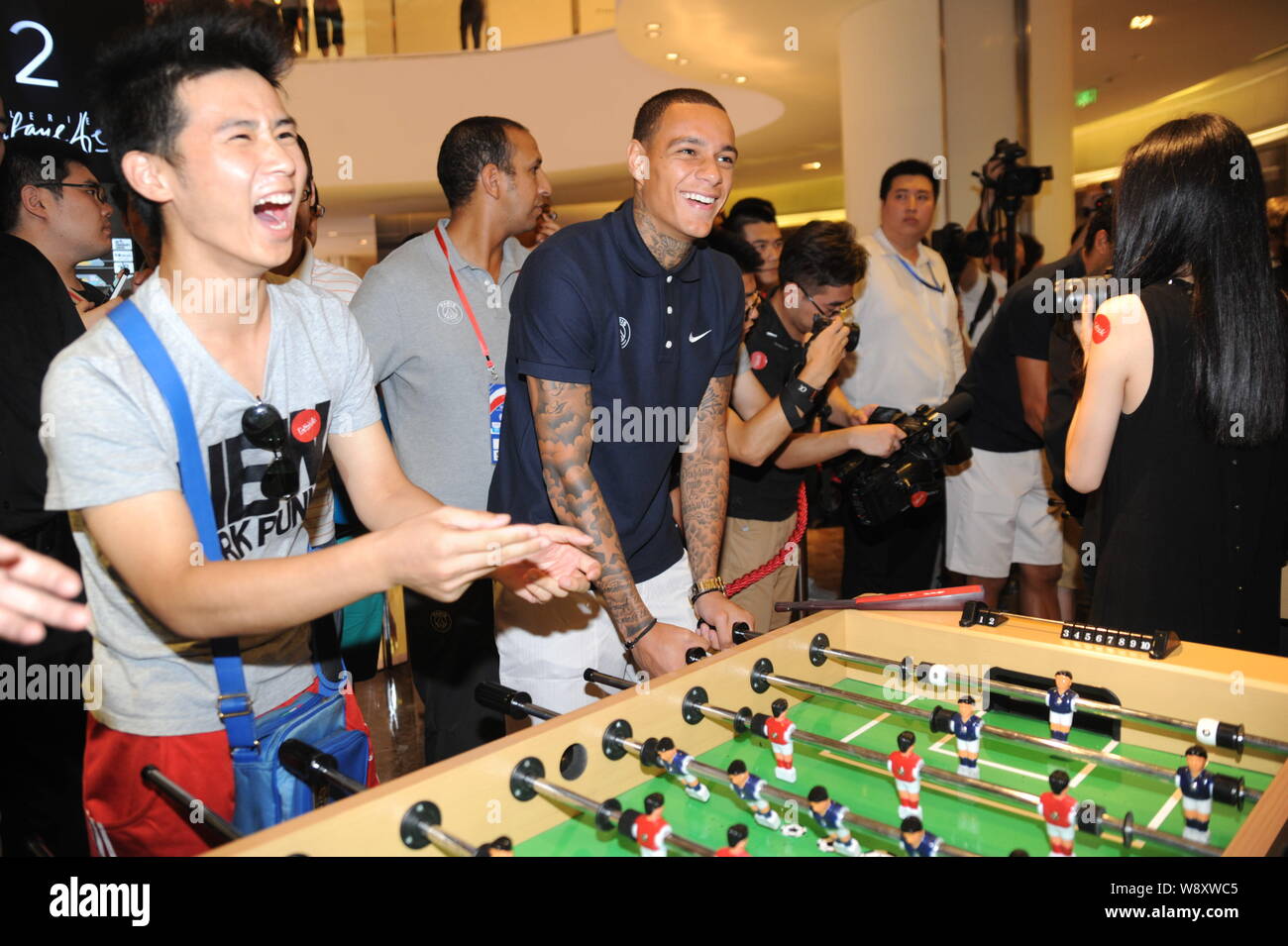 Gregory van der Wiel, left, and Marquinhos of Paris Saint-Germain football  club prepare to cut the ribbon during the opening ceremony for the Pop up S  Stock Photo - Alamy