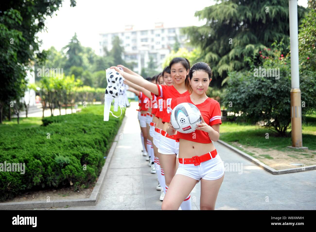 Young women hold their football-patterned bras to protest being