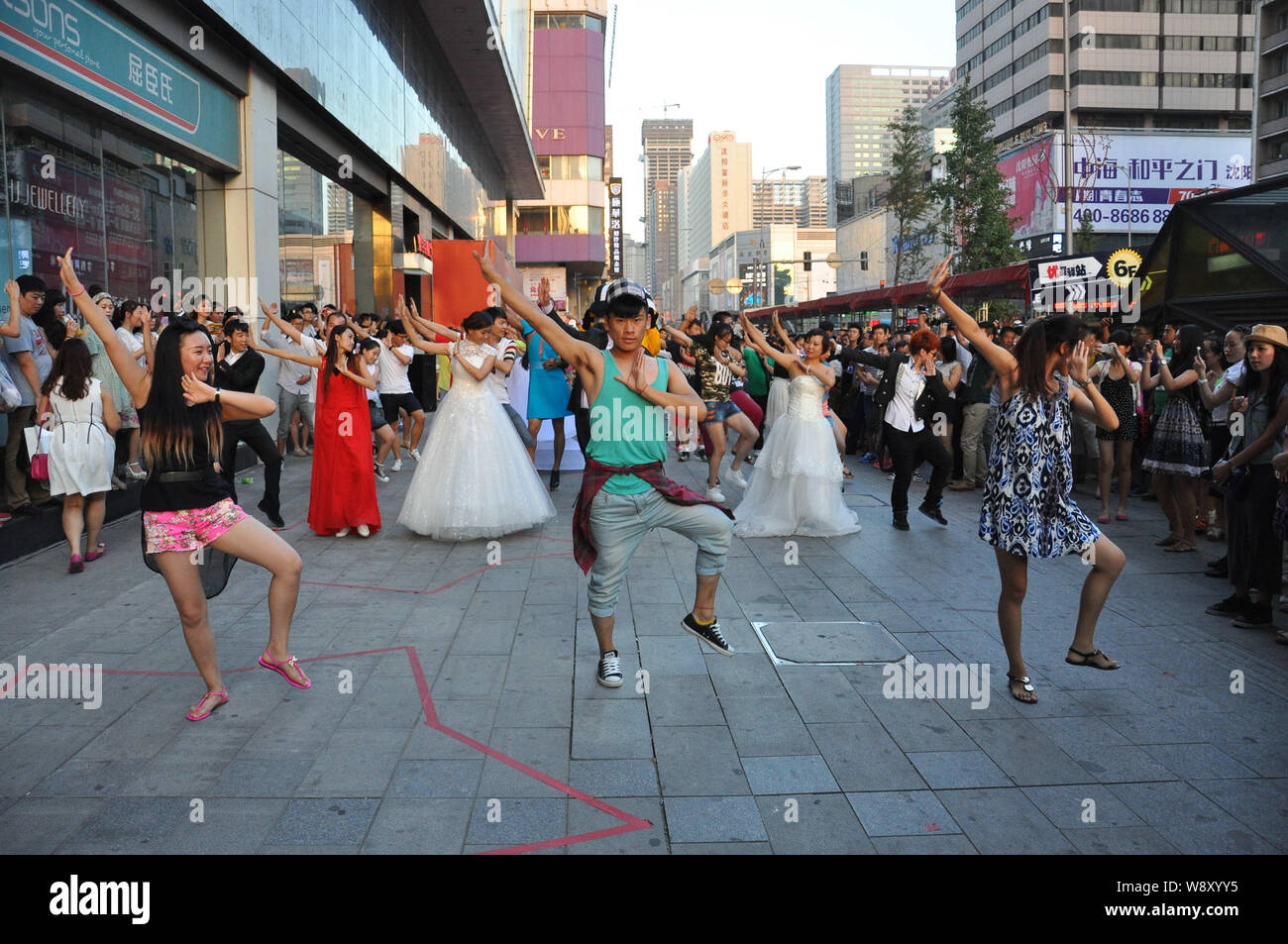 --FILE--Young people dance to the music of Little Apple during an event in front of a shopping mall in Shenyang city, northeast Chinas Liaoning provin Stock Photo
