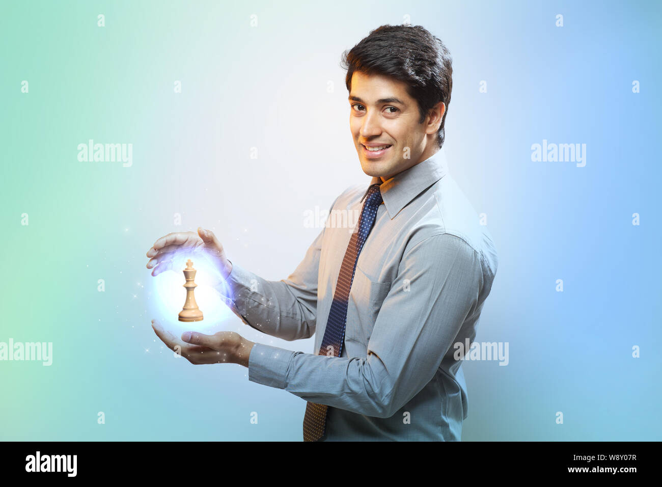 Businessman holding a glowing king chess piece Stock Photo