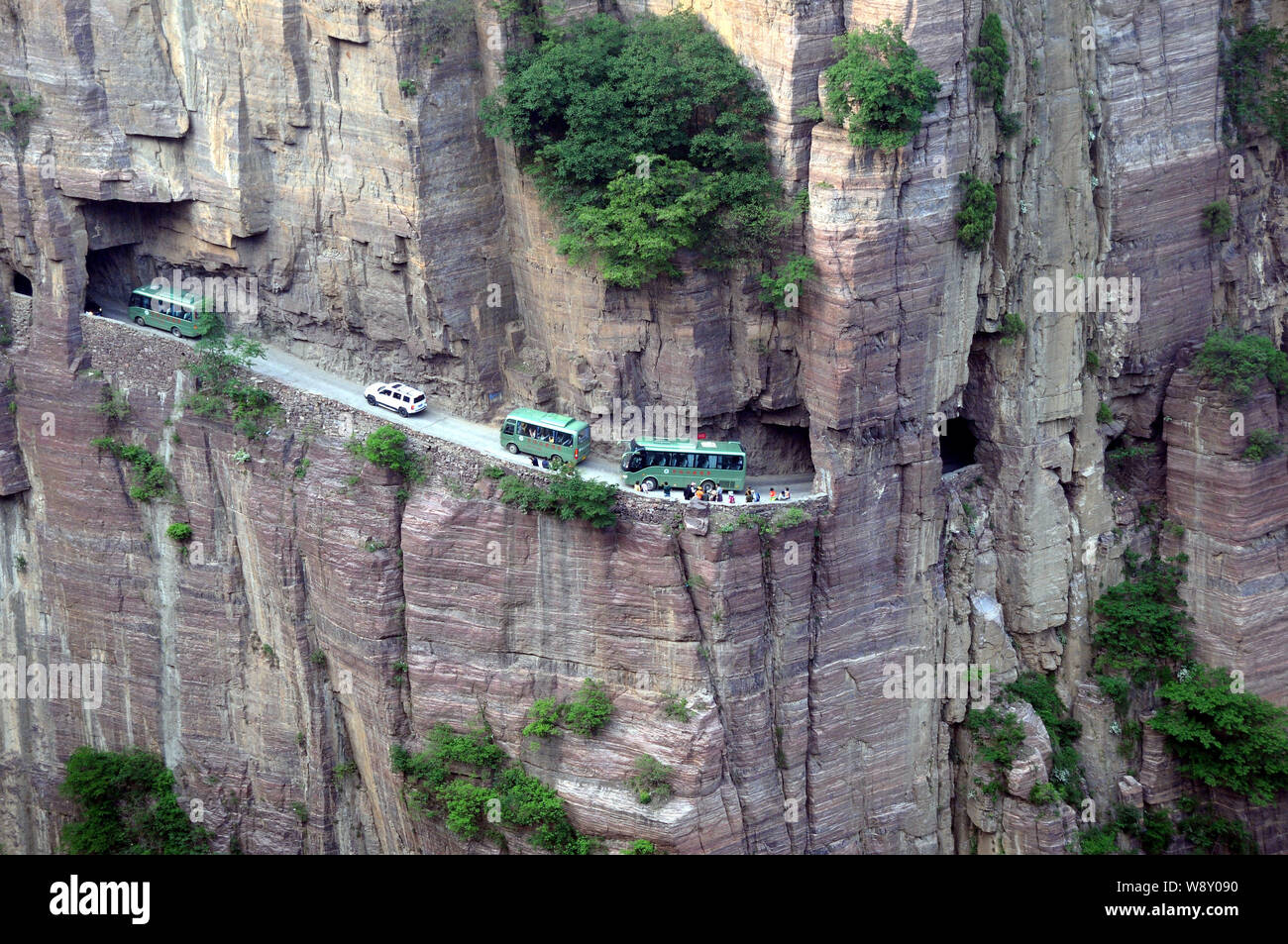 --FILE--Buses and cars travel along the Guoliang Tunnel through the Wanxian Mountain in the Taihang Mountains in Huixian county, Xinxiang city, centra Stock Photo