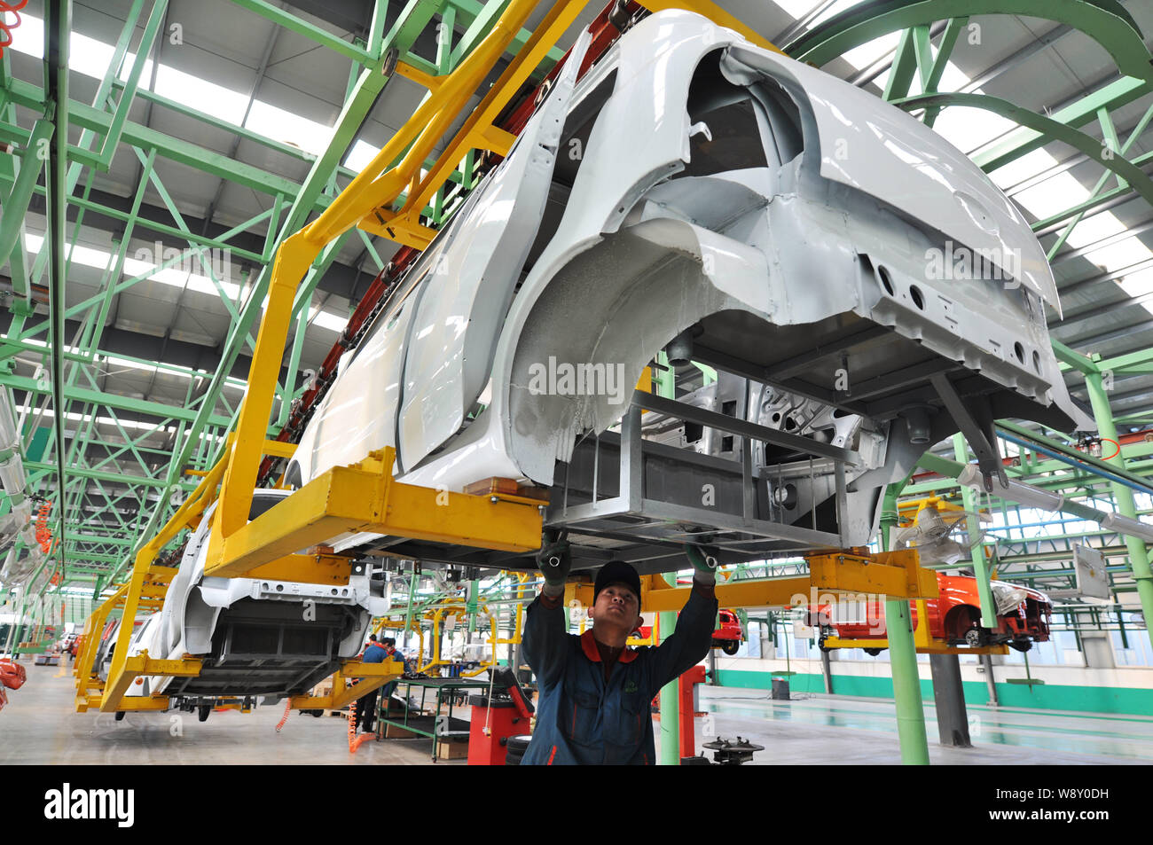 Chinese workers assemble electric cars on the assembly line at the auto ...
