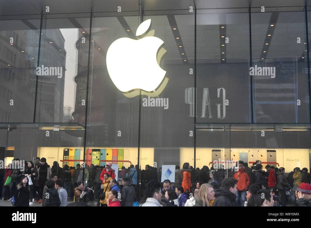 --FILE--Pedestrians crowd in front of the Apple Store on the Nanjing Road shopping street in Shanghai, China, 29 December 2013.   China attracted a re Stock Photo