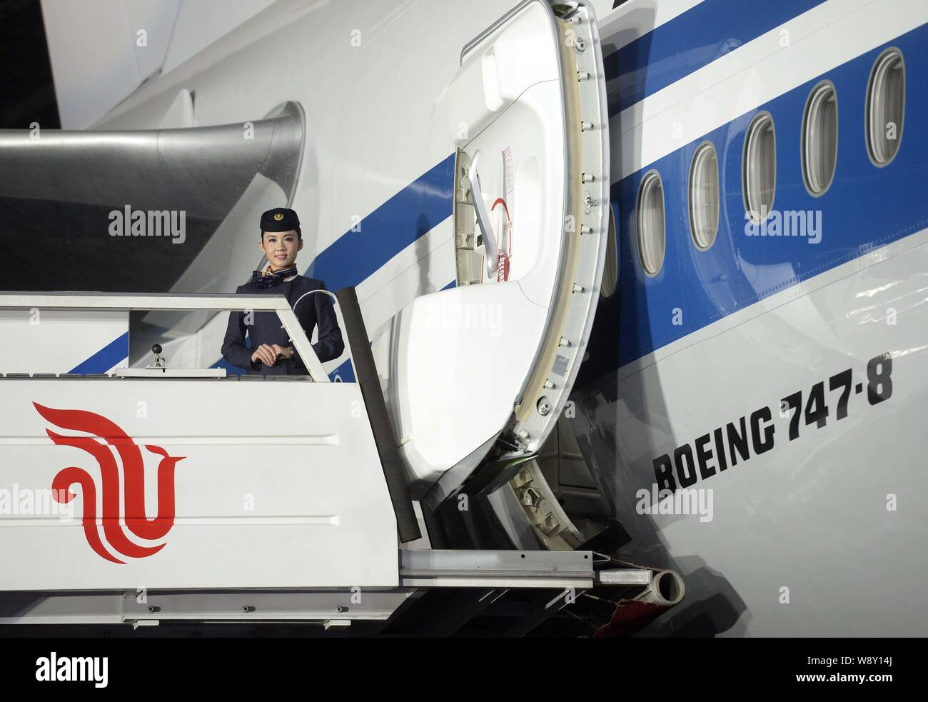 --FILE--A flight attendant is seen on the gangway next to a Boeing 747-8 jet plane of Air China at a Boeing 747-8's launch event in Beijing, China, 9 Stock Photo