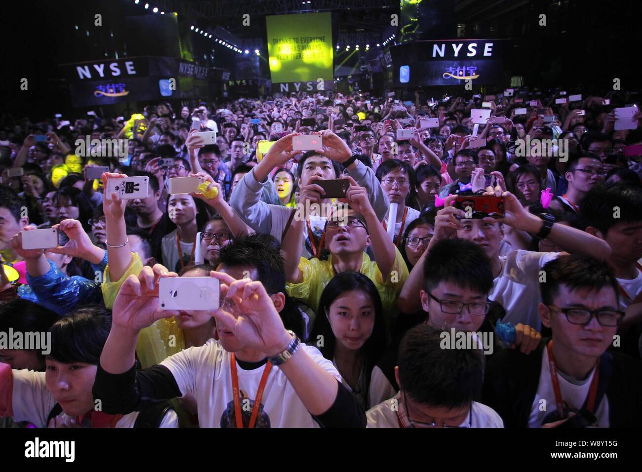 Chinese employees of Alibaba Group take photos to celebrate Alibaba's IPO on the New York Stock Exchange at the headquarters of Alibaba Group in Hangz Stock Photo