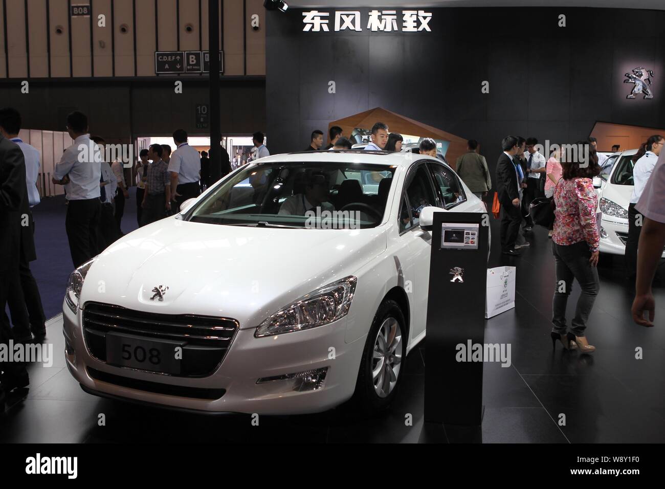 --FILE--Visitors walk past a Dongfeng Peugeot 508 during an automobile exhibition in Shanghai, China, 30 September 2013.   The board of loss-making ca Stock Photo