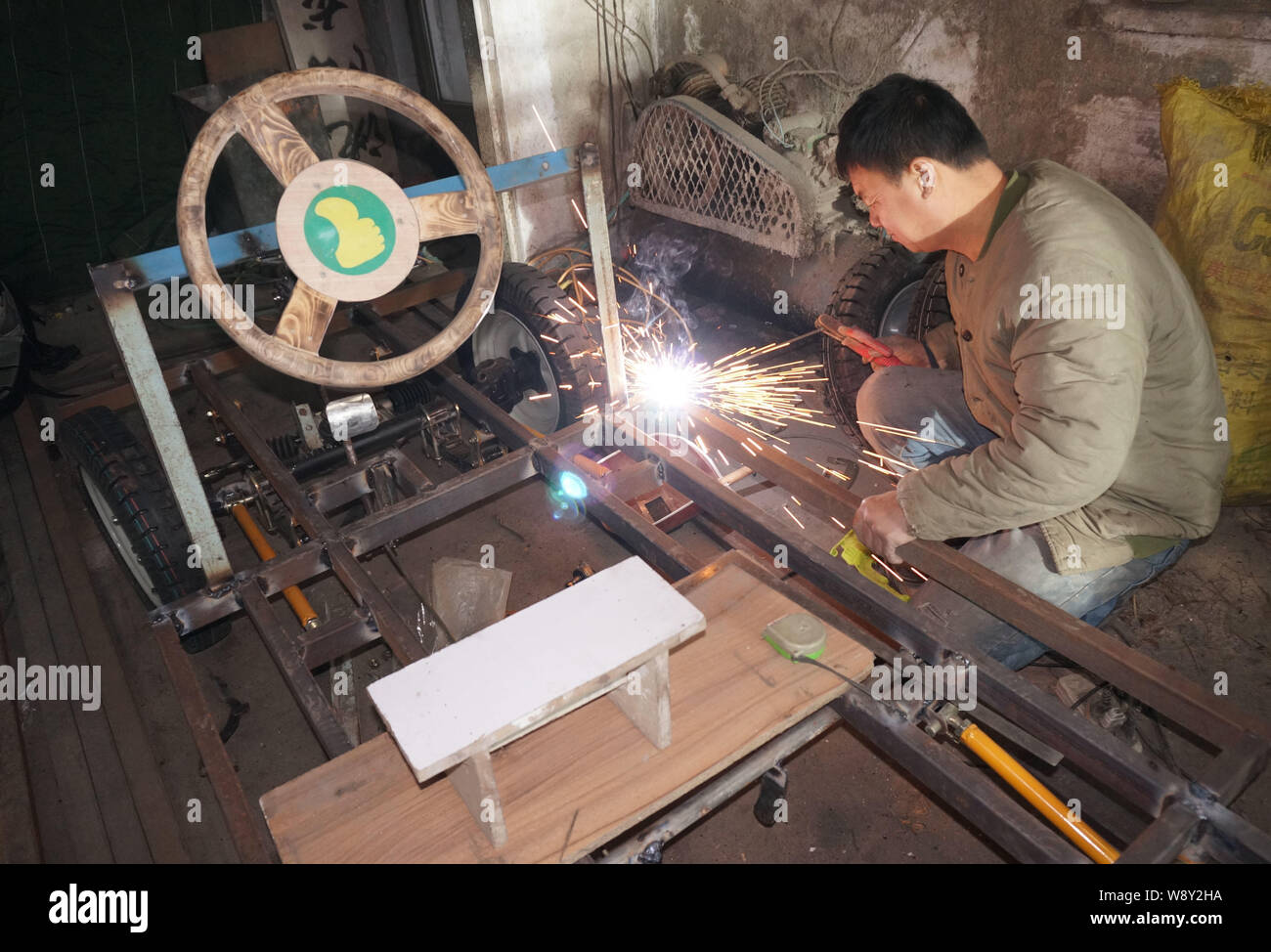 Chinese carpenter Liu Fulong welds the chassis of his homemade electric