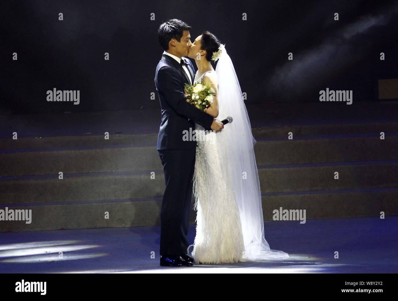 American actor Archie Kao, left, and Chinese actress Zhou Xun in a white wedding dress kiss after announcing their wedding during the One Night charit Stock Photo