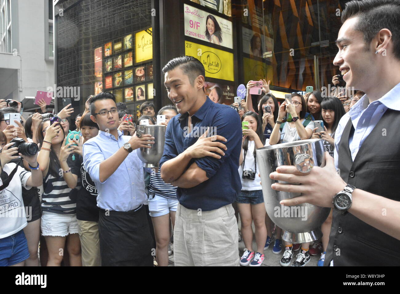 Choi Siwon of South Korean pop group Super Junior, second right, prepares for the Ice Bucket Challenge in Central, Hong Kong, China, 18 August 2014. Stock Photo