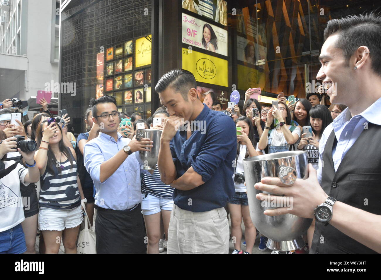 Choi Siwon of South Korean pop group Super Junior, second right, prepares for the Ice Bucket Challenge in Central, Hong Kong, China, 18 August 2014. Stock Photo