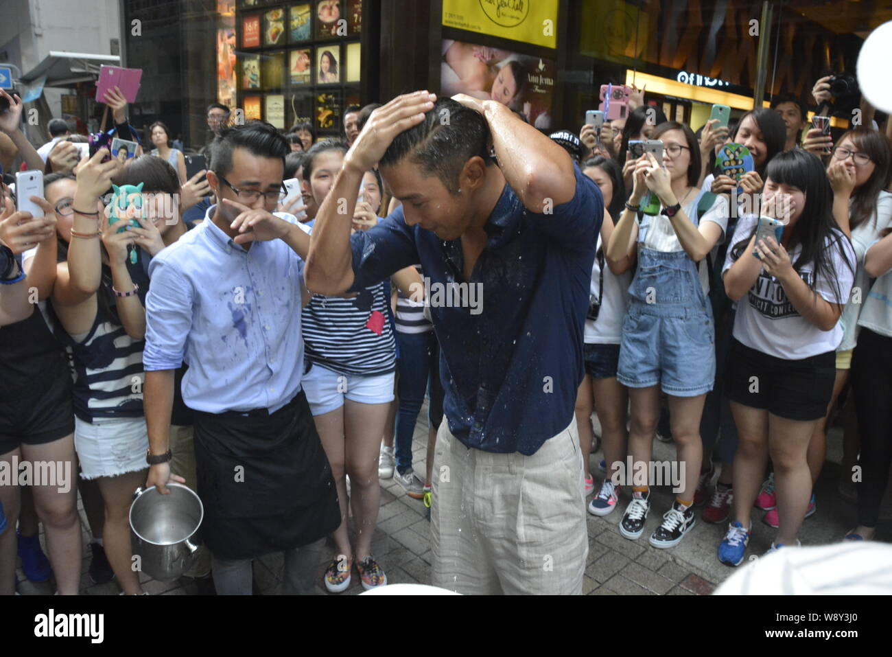 Choi Siwon of South Korean pop group Super Junior, front, gets soaked after braving the Ice Bucket Challenge in Central, Hong Kong, China, 18 August 2 Stock Photo