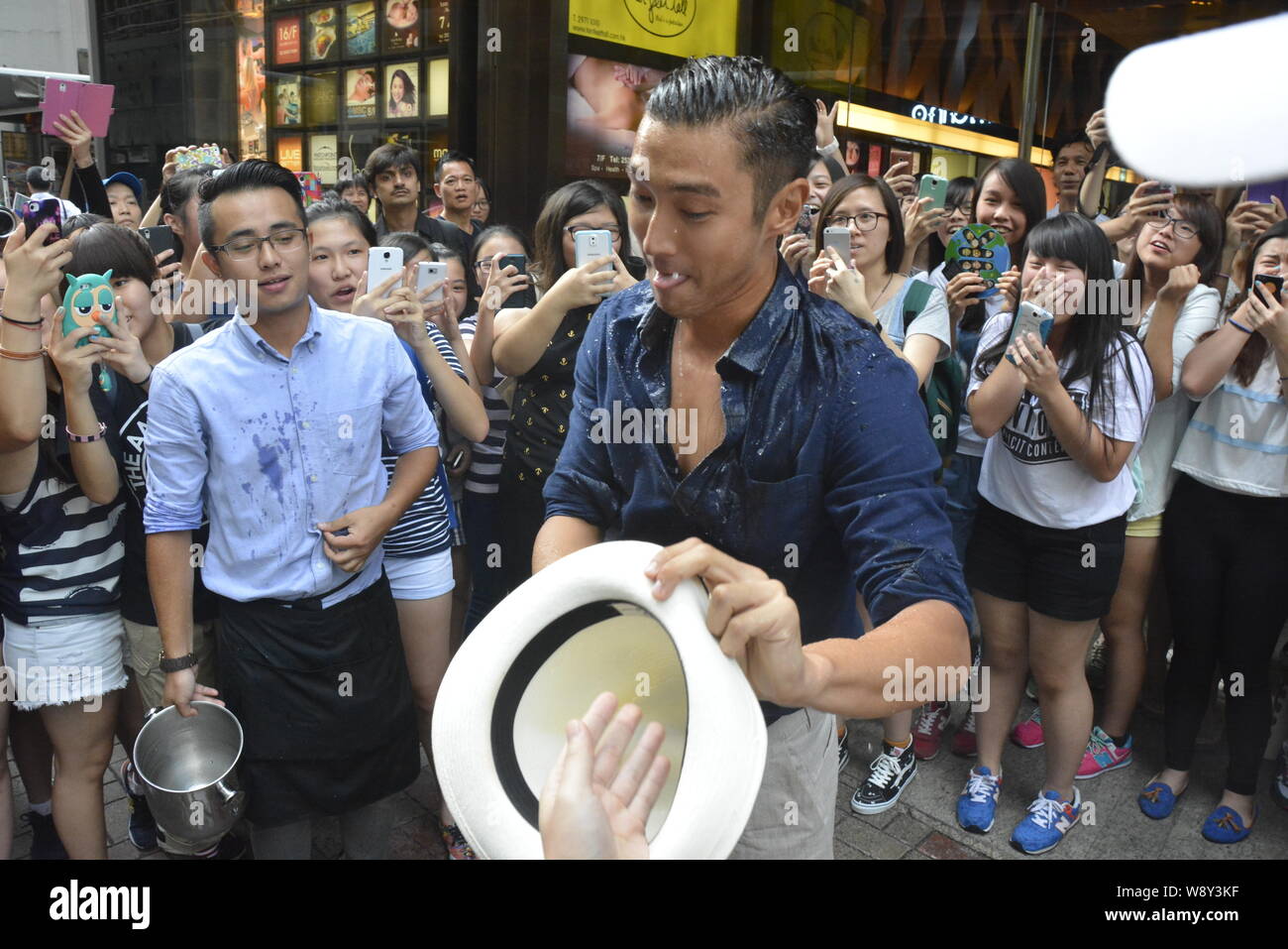 Choi Siwon of South Korean pop group Super Junior, front, reacts after braving the Ice Bucket Challenge in Central, Hong Kong, China, 18 August 2014. Stock Photo