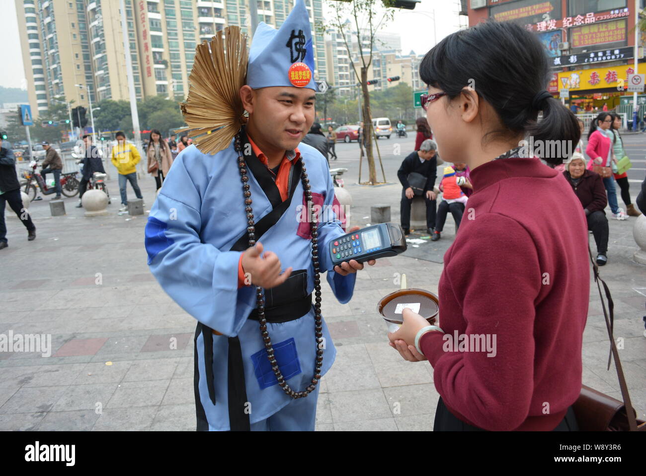 Chinese businessman Wang Jiang, left, dressed like a beggar in a costume of Chinese Buddhist monk Daoji, also known as Ji Gong, of the Southern Song D Stock Photo