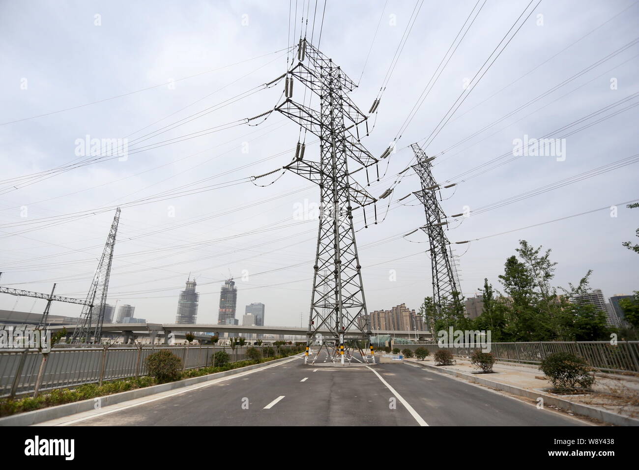 A pylon bearing electric wires is pictured in the middle of a newly-built highway in Zhengzhou city, central Chinas Henan province, 15 May 2014.   The Stock Photo