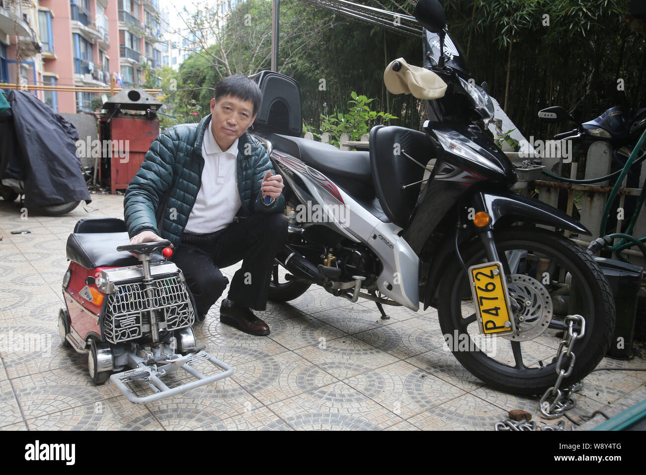 60-year-old Xu Zhiyun show the mini car assembled by himself at his home in Shanghai, China, 29 November 2014.   Xu Zhiyun, a 60-year-old native of Sh Stock Photo