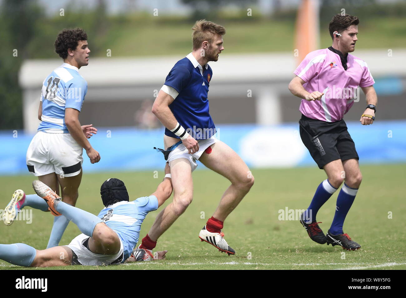 Juan Ignacio Conil Vila of Argentina, left front, pulls down the shorts of Sacha Valleau of France, second right, at the Rugby Sevens final during the Stock Photo