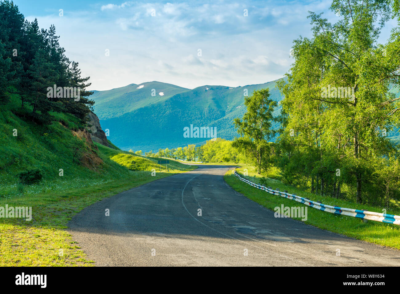 Empty automobile mountain road on a sunny summer day in the picturesque mountains of Transcaucasia, the landscape of Armenia Stock Photo