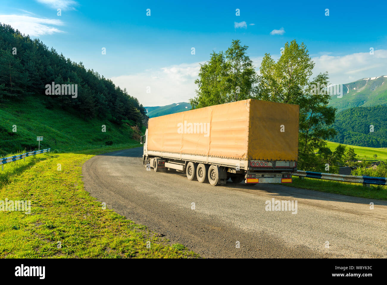 Heavy wagon loaded on roads of mountain serpentines in Armenia Stock Photo