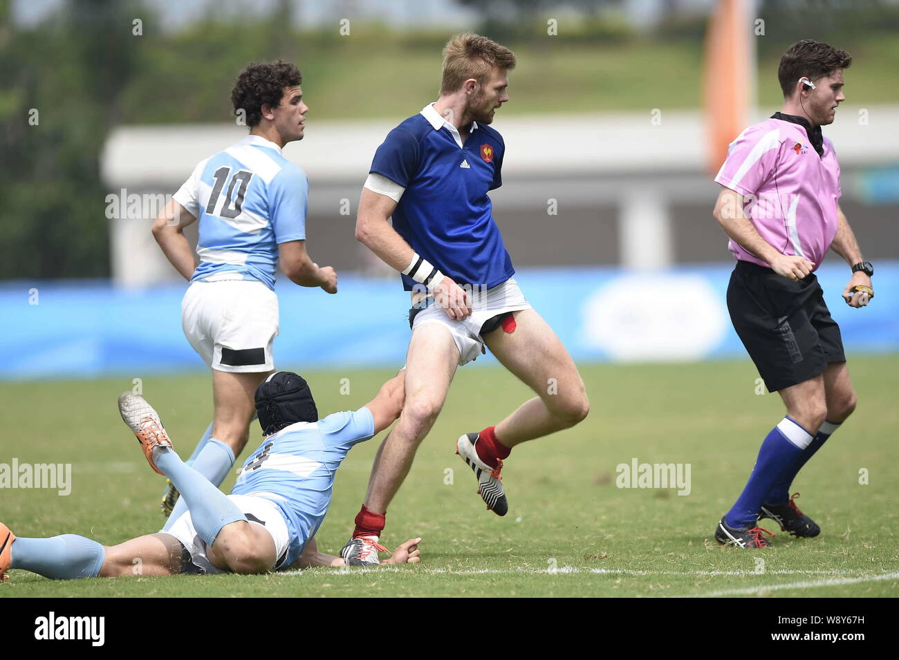 Juan Ignacio Conil Vila of Argentina, left front, pulls down the shorts of Sacha Valleau of France, second right, at the Rugby Sevens final during the Stock Photo