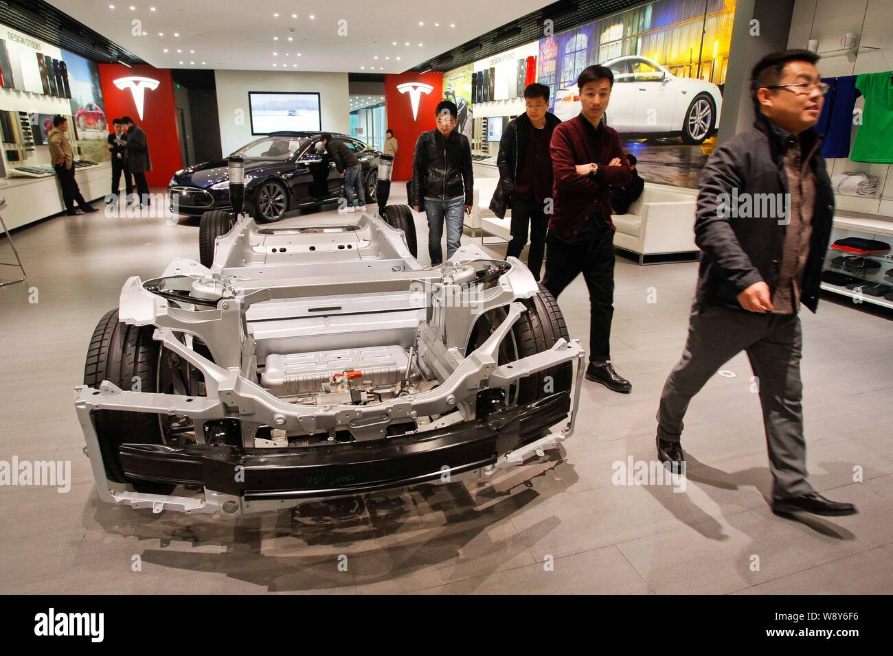 --FILE--Visitors walk past a chassis of the Model S on display at the Tesla store in Beijing, China, 28 February 2014.   US electric carmaker Tesla Mo Stock Photo