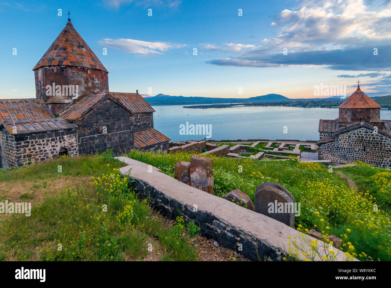 Architecture of Armenian temples View of Sevanavank Monastery and Lake Sevan at sunset Stock Photo