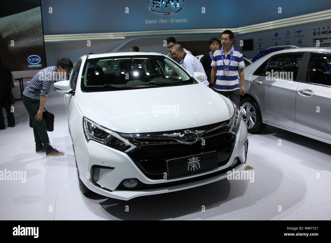 --FILE--Visitors look at a plug-in hybrid Qin of BYD during the 13th ...