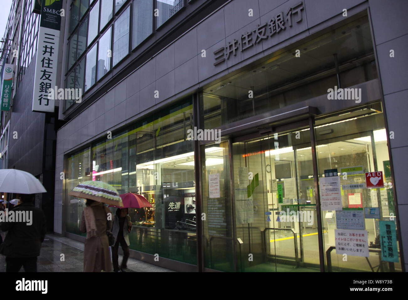 --FILE--Pedestrians walk past a branch of Sumitomo Mitsui Banking Corp. (SMBC) in Tokyo, Japan, 1 December 2011.   Citigroup has agreed to sell its re Stock Photo