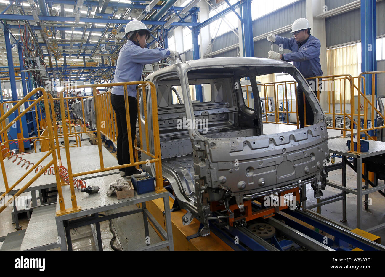 --FILE--Chinese workers assemble a car on the assembly line at an auto ...