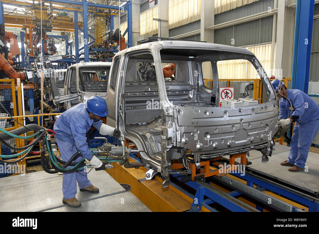 --FILE--Chinese workers assemble a car on the assembly line at an auto ...