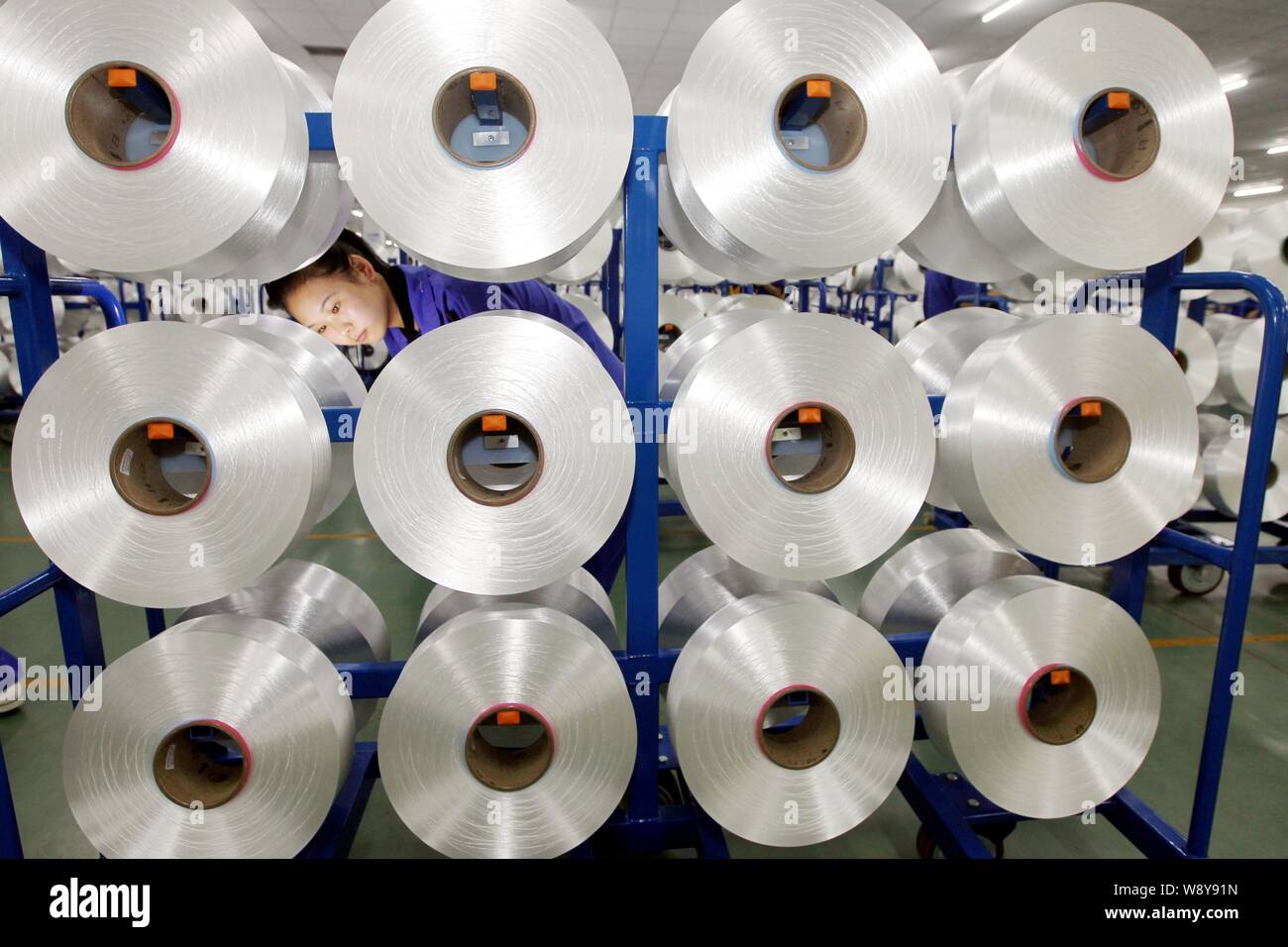 --FILE--A female Chinese worker checks chemical fibre at a textile ...