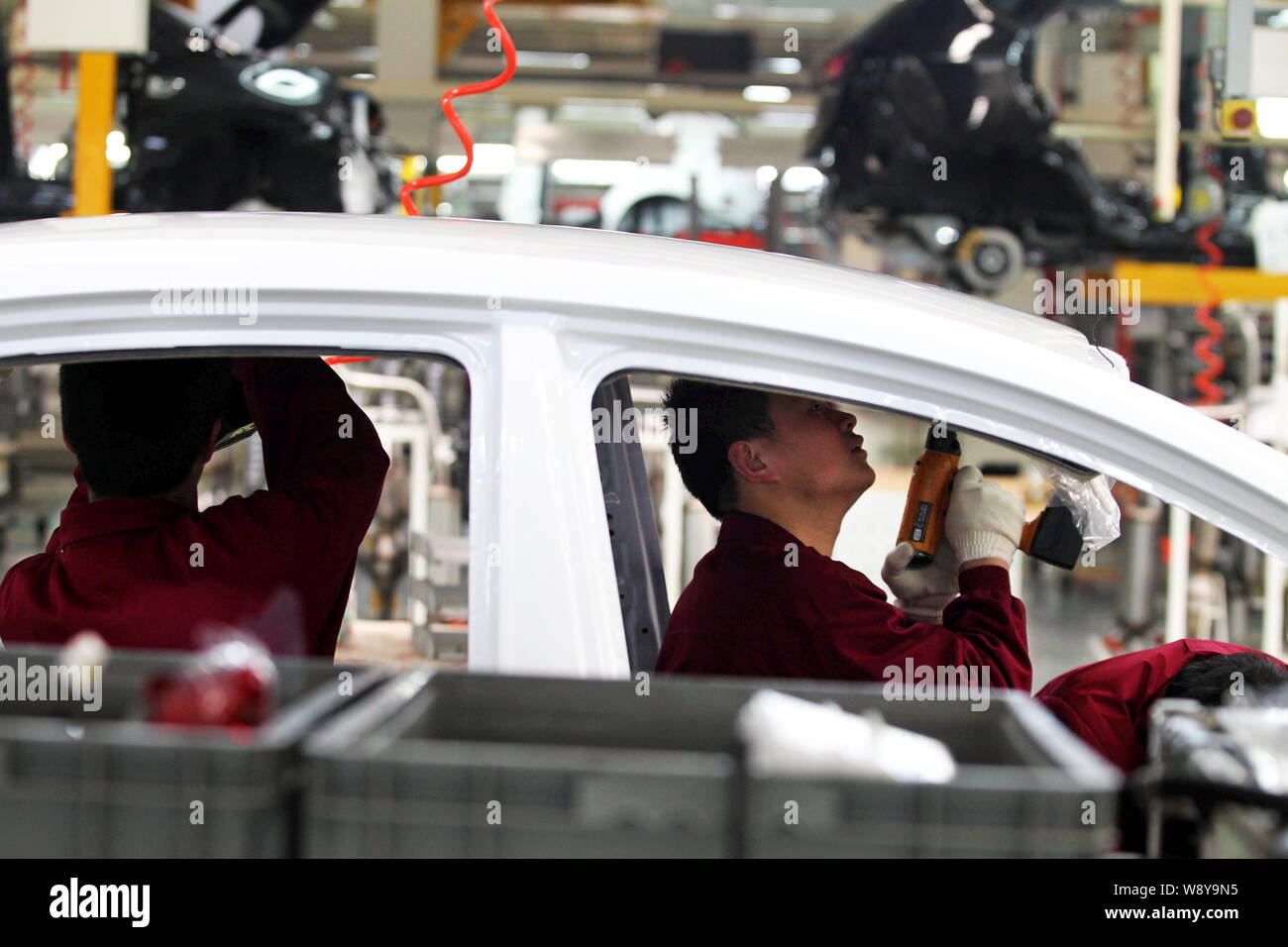 --FILE--Chinese workers assemble a car on the assembly line at the auto ...