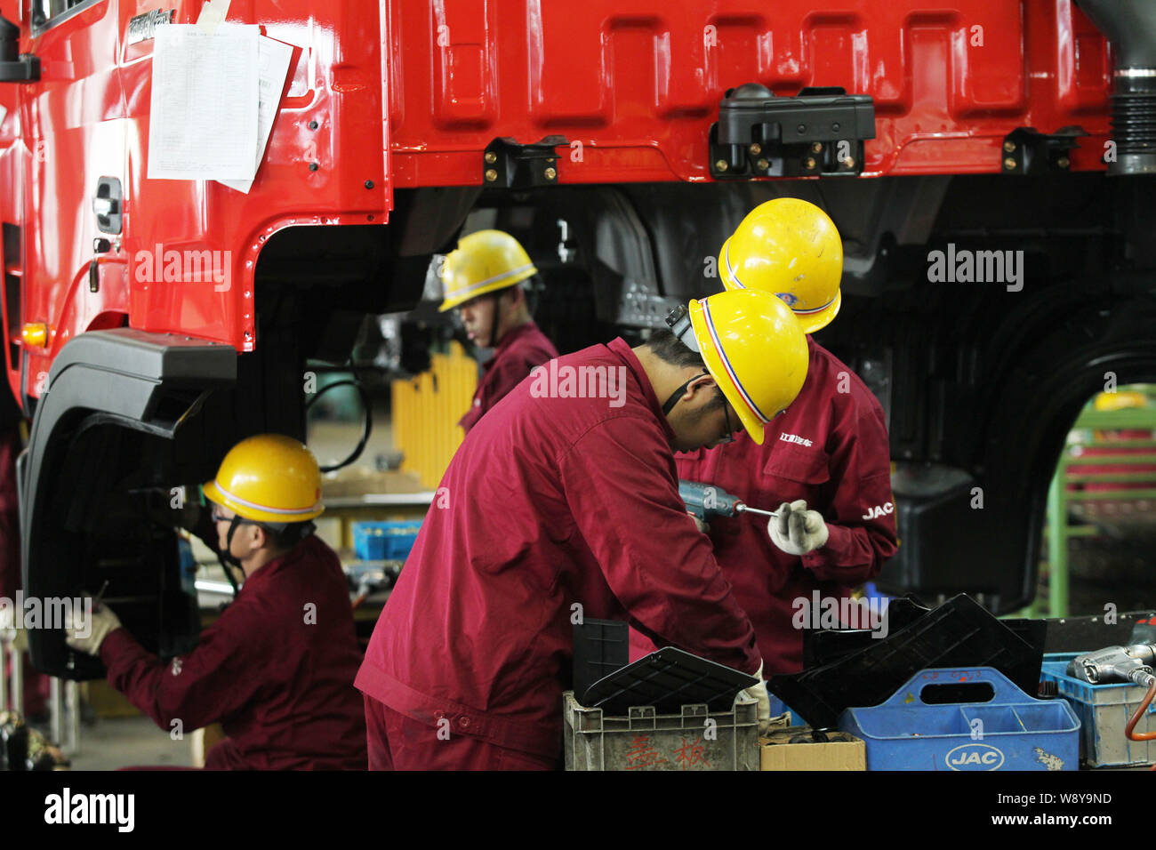 --FILE--Chinese workers assemble a truck on the assembly line at the ...