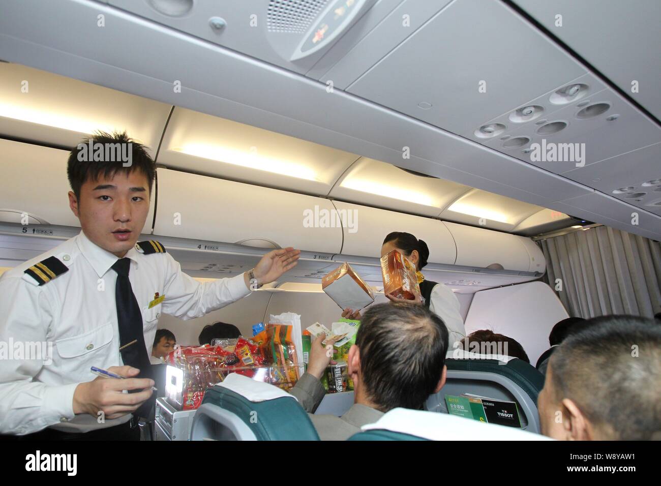 --FILE--Cabin crew members of Spring Airlines sell products during a flight from Harbin city to Shanghai, China, 2 April 2011.   As Chinas myriad socc Stock Photo