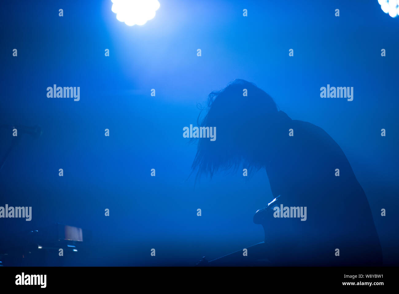 Silhouette of a guitarist in blue stage lights Stock Photo