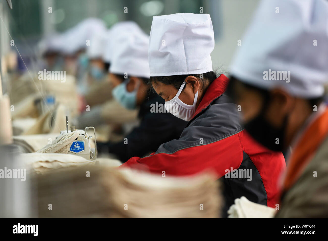 --FILE--Female Chinese workers sew clothes to be exported to the United States at a garment factory in Zouping county, east China's Shandong province, Stock Photo
