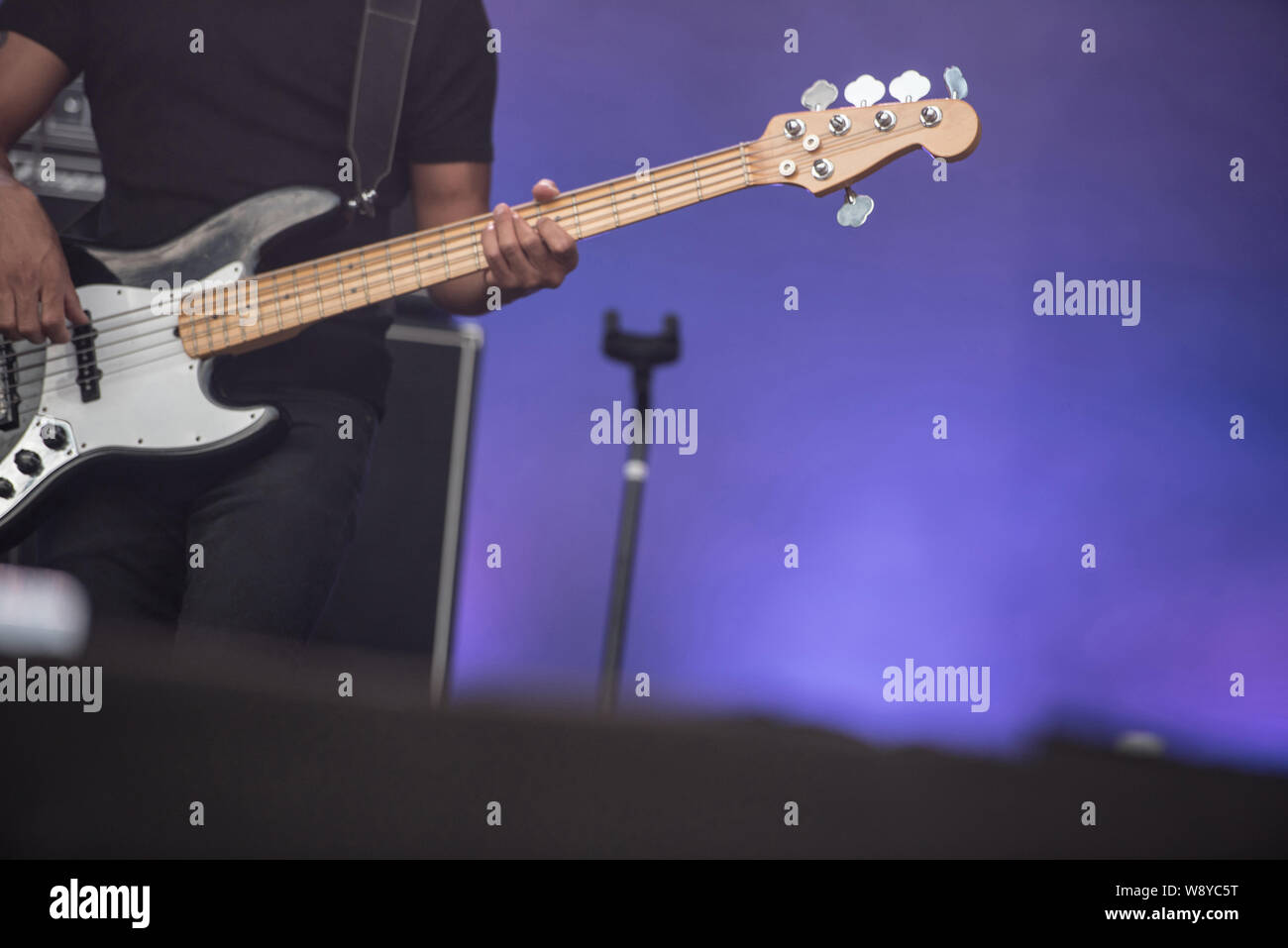 Detail of a musician playing on a bass guitar at concert Stock Photo ...