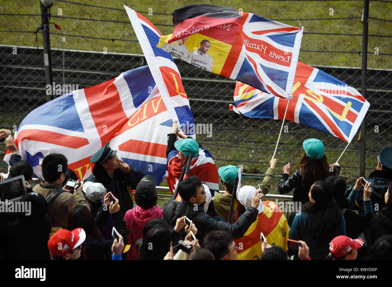Fans of British F1 driver Lewis Hamilton of Mercedes AMG Petronas F1 Team waves national flags of UK after he finished first during the 2014 Formula 1 Stock Photo