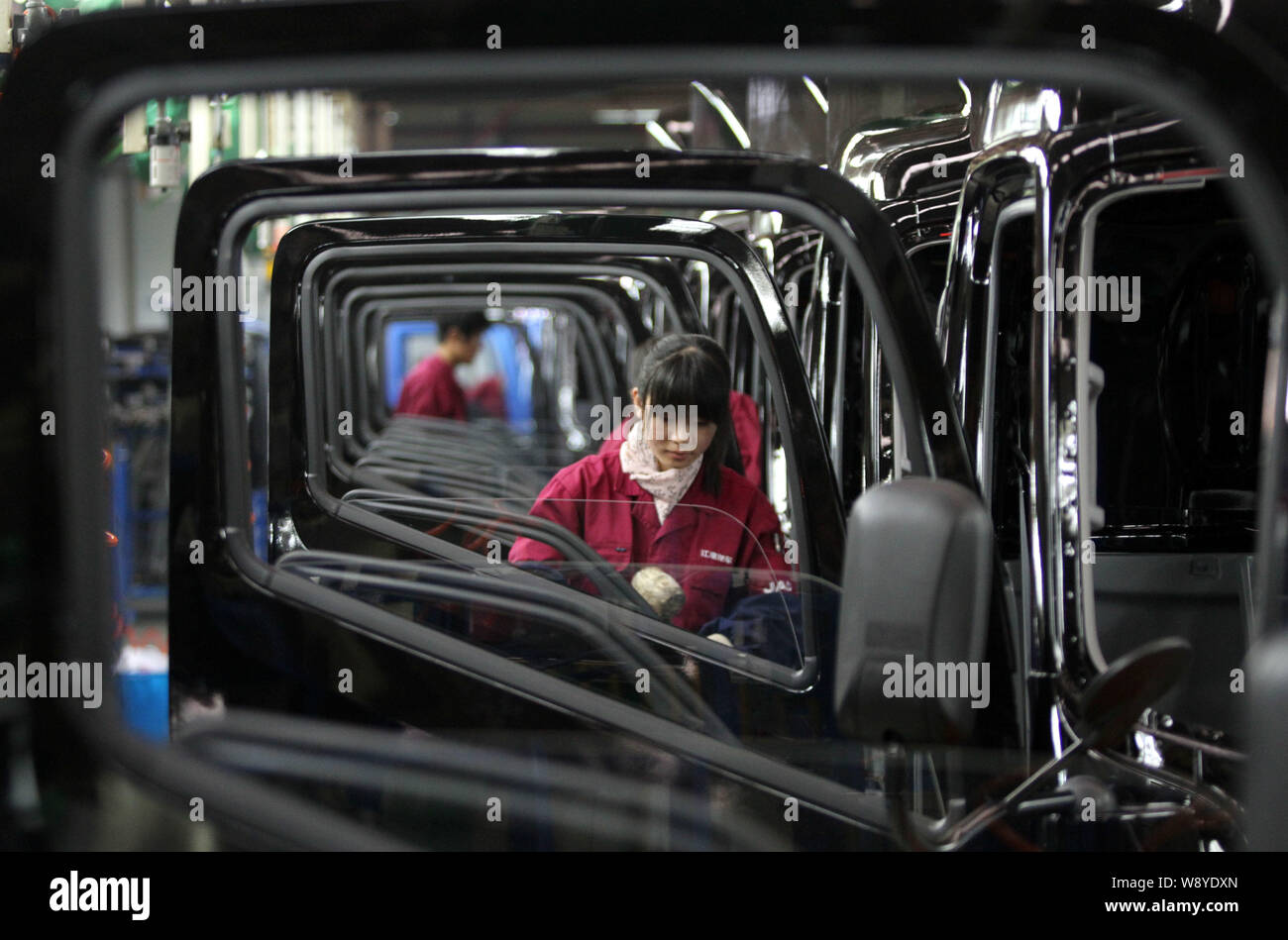--FILE--A female Chinese worker assembles a car on the assembly line at ...