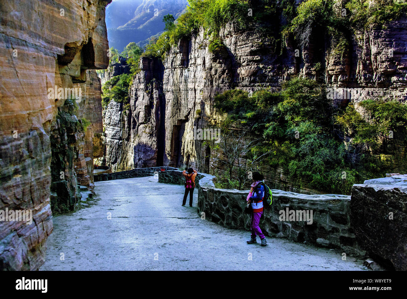 Tourists walk along the road linking to the Guoliang Tunnel through the Wanxian Mountain in the Taihang Mountains in Huixian county, Xinxiang city, ce Stock Photo