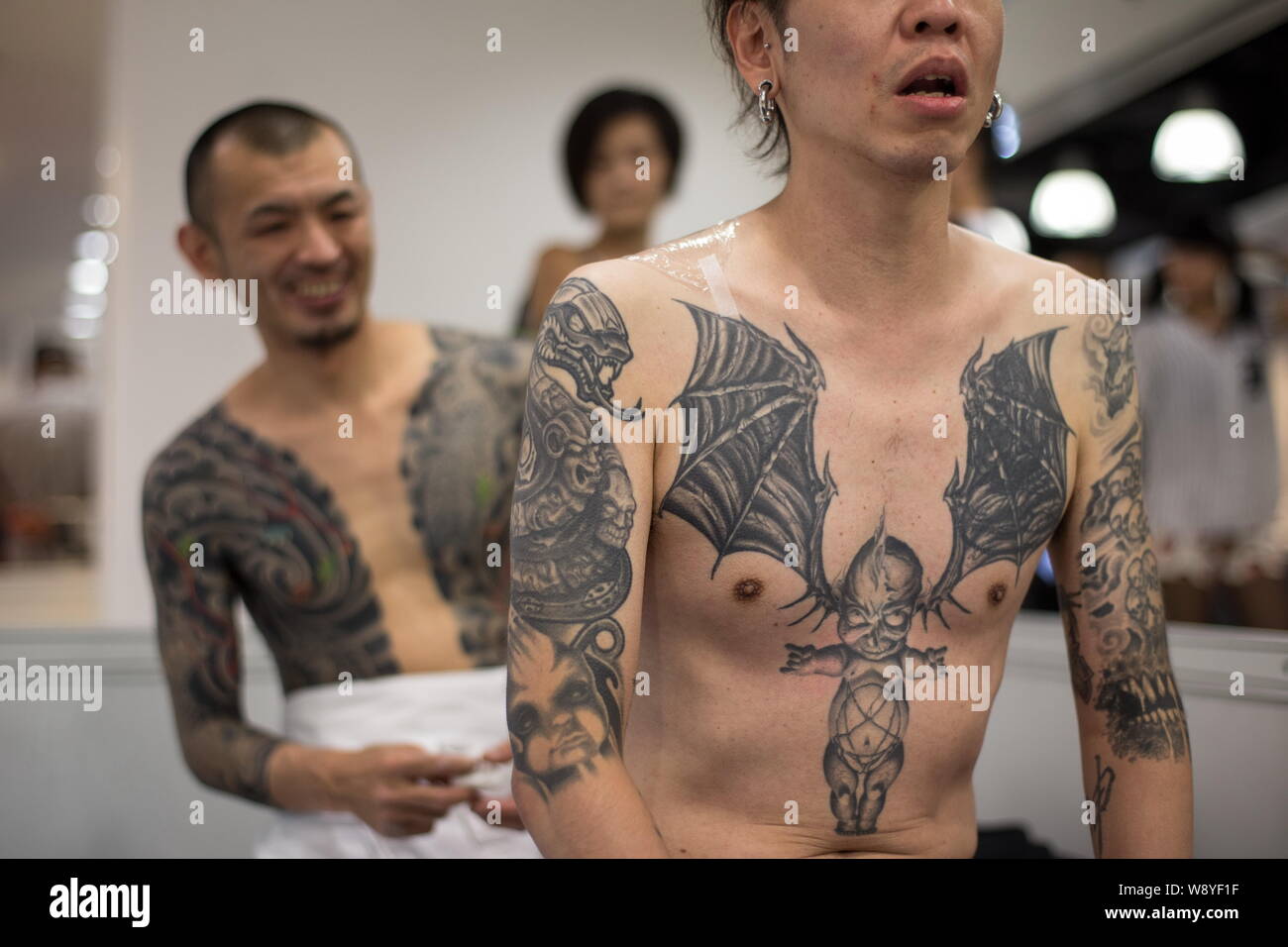 Japanese tattoo artist Sousyo Hayashi, left, smiles as he looks at his new creation during the Second International Hong Kong Tattoo Convention in Kow Stock Photo