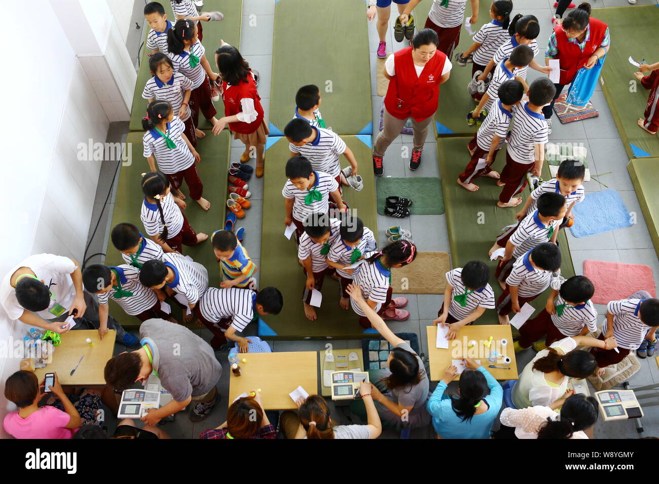 Young students queue up to be weighed during a physical examination at a school in Shanghai, China, 27 May 2014.   China is getting fatter and it is w Stock Photo
