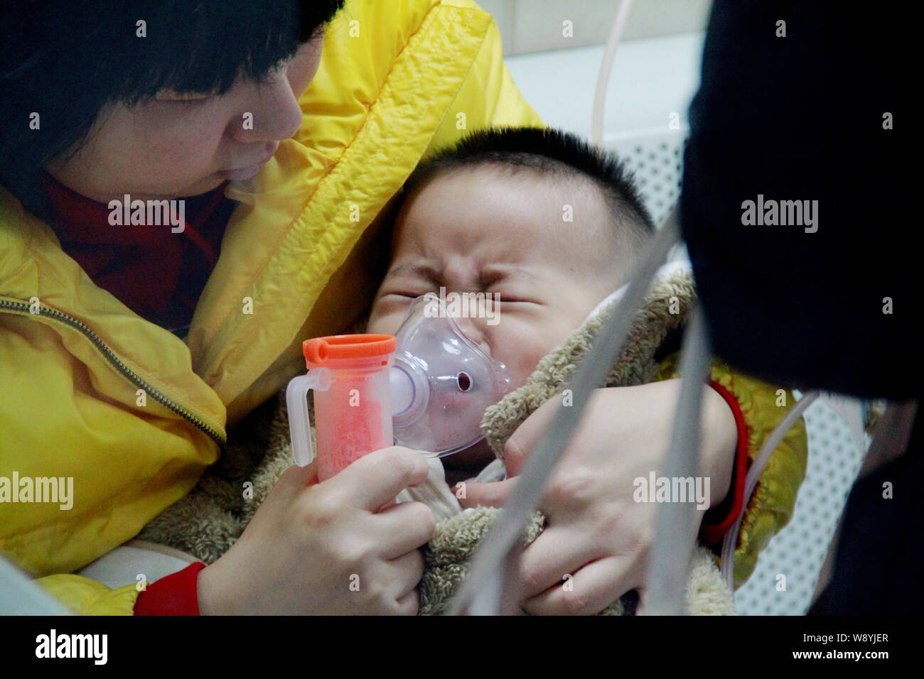 --FILE--A Chinese mother helps her son who suffers from respiratory illness due to smog with nebulization theraphy at a hospital in Beijing, China, 31 Stock Photo