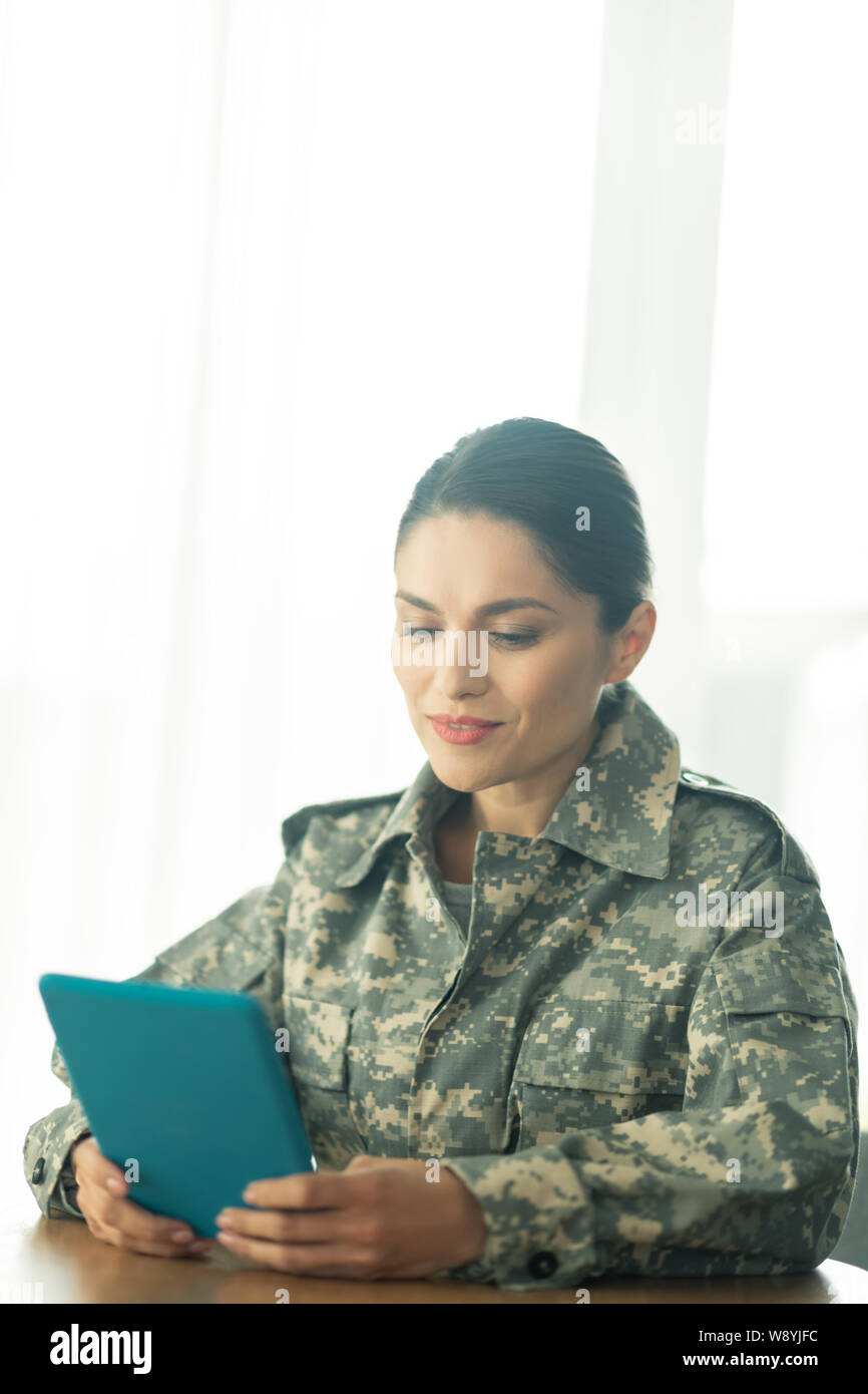 Female soldier holding tablet and chatting with her family Stock Photo